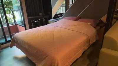 a bedroom with a bed with a white comforter at brown condo Phahon67 in Ban Chuat Plai Mai