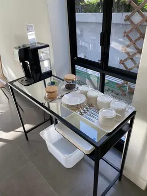 a glass table with plates and cups and a coffee maker at The Celestrail - Apartment - Check-In by Appointment Only - Non-hotel - Onnut BTS in Amphoe Phra Khanong