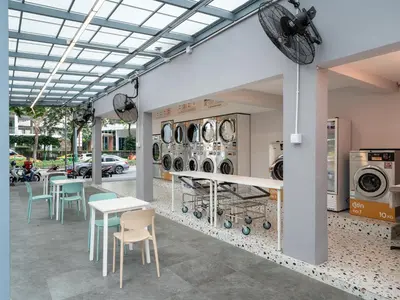 a room with tables and chairs and washing machines at Wash House Chatuchak in Bangkok