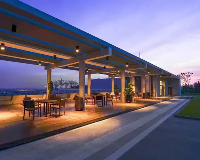 a building with tables and chairs on a deck at night at Tranquil Urban Retreat at Cheangwattana in Pak Kret