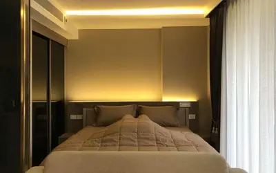 a bedroom with a large bed with a light above it at Luxury condo right next to BTS Thonglor! in Bangkok