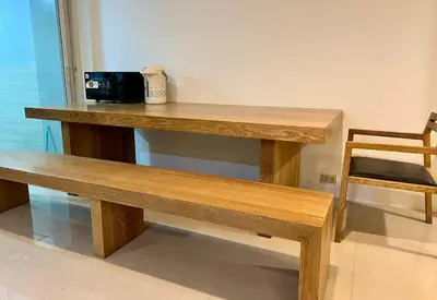 a wooden table and a bench in a room at Comfy Crib Hostel 2 in Bangkok
