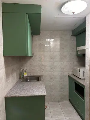a kitchen with green cabinets and a sink at Spacious room in Sukhumvit Nana in Bangkok