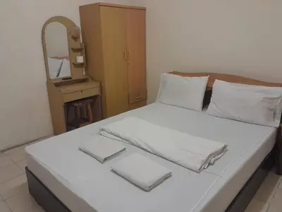 a bedroom with a bed with white sheets and a mirror at Nakara Place บ้าน นาครา in Ban Rang Pho