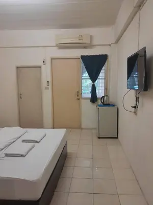 a bedroom with a bed and a flat screen tv at Nakara Place บ้าน นาครา in Ban Rang Pho