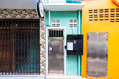 a door to a building next to a fence at xx GO INN The Giant Swing โก อินน์ เสาชิงช้า in Bangkok