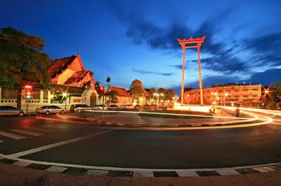 a city street at night with a large roundabout at xx GO INN The Giant Swing โก อินน์ เสาชิงช้า in Bangkok