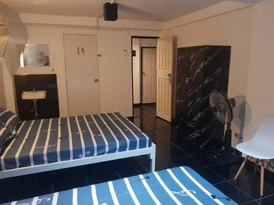 a room with two beds and a fan at Jay Jay Guesthouse in Bangkok