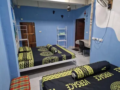 two beds in a room with blue walls at Jay Jay Guesthouse in Bangkok