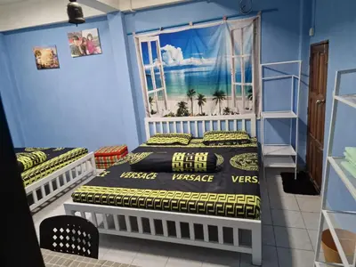 two beds in a room with a window at Jay Jay Guesthouse in Bangkok