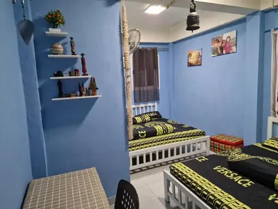 two twin beds in a room with blue walls at Jay Jay Guesthouse in Bangkok