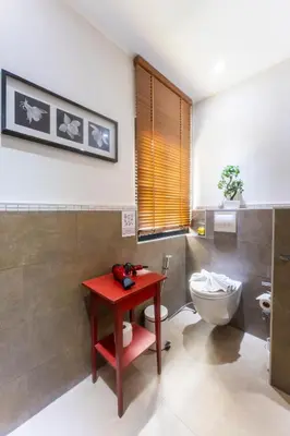 a bathroom with a red table and a toilet at Mak Sukhumvit 15 in Bangkok