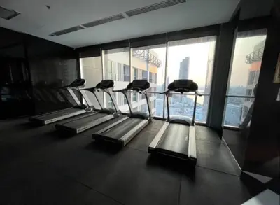 a group of treadmills in a gym with a view of the city at Opulence Riverview with Train Access in Bangkok
