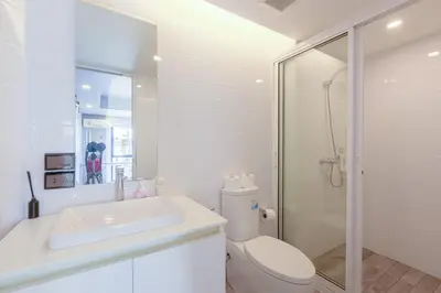 a bathroom with a toilet and a sink and a shower at Quite Grove Hotel in Bangkok
