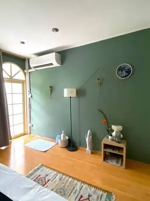 a room with a green wall with a lamp and a table at Entire House 6 people 3Beds 2Baths near BTS Asoke Terminal21 in Bangkok