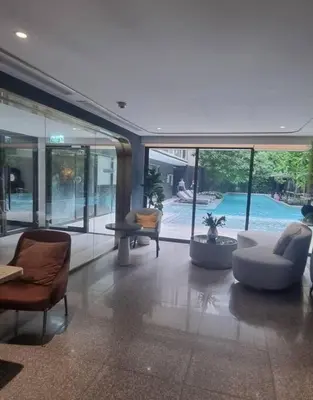 a living room with couches and chairs and a pool at Luxury and cozy apartment in the City center in Bangkok