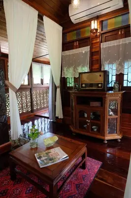 a living room with a table and a tv at เรือนไทยพราวพิมาน Proudpiman Thai Heritage House in Ban Bang Toei (1)