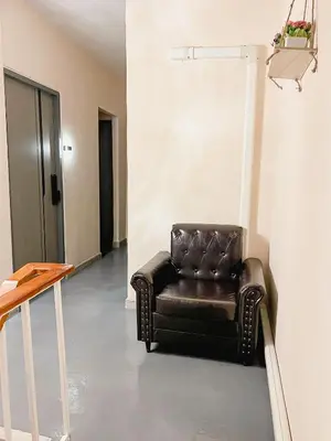 a brown leather chair sitting in a room at Moochi Relax L'Assommior in Bangkok