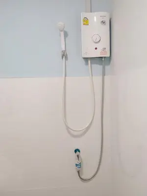 a bathroom with a blow dryer on a wall at Moochi Relax L'Assommior in Bangkok