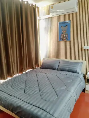 a large bed in a bedroom with a window at Moochi Relax L'Assommior in Bangkok