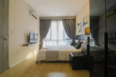a hotel room with a bed and a window at Cosy apartment - BTS Phrom phong in Bangkok