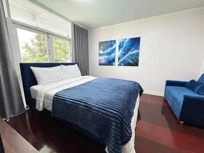 a bedroom with a bed and a blue chair at EM HOME Sukhumvit Bangkok - near Terminal 21, EM District Malls, BTS and MRT Lines in Bangkok