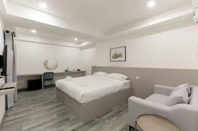a bedroom with a bed and a couch and a tv at P9 Ratchada Hotel in Bangkok
