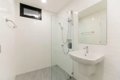 a white bathroom with a sink and a shower at P9 Ratchada Hotel in Bangkok