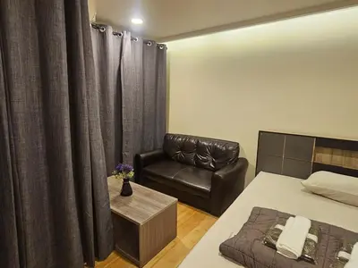 a bedroom with a bed and a leather chair at forest by Bangboon by Parisa in Sathani Wat Sing