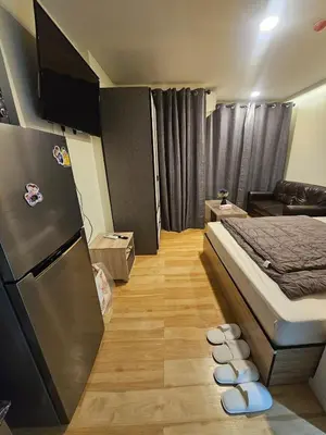 a small room with a bed and a refrigerator at forest by Bangboon by Parisa in Sathani Wat Sing