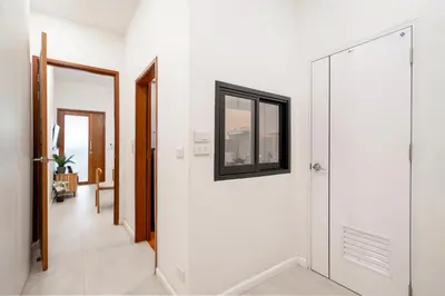 a hallway with white walls and a mirror at 4BR Walk to Chinatown, MRT Luggage Dropoff in Bangkok