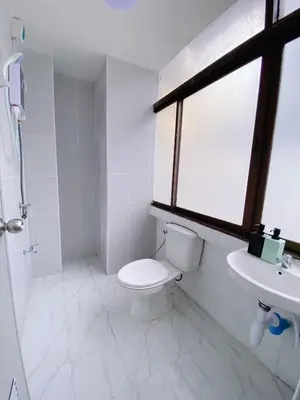 a bathroom with a toilet and a sink and a window at XX GO INN MRT Hua Lamphong China Town in Bangkok