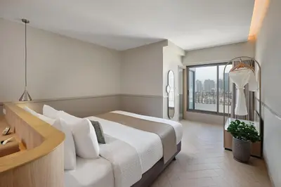a bedroom with a large bed and a large window at Somerset Sukhumvit 71 Bangkok in Bangkok