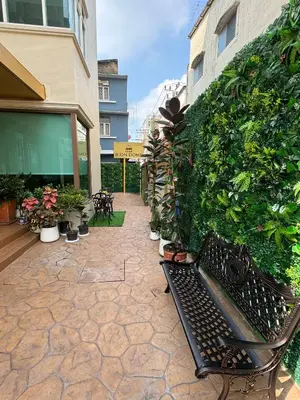 a bench sitting in front of a wall with plants at Icon Dome Bangkok in Bangkok