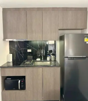 a kitchen with a stainless steel refrigerator and a sink at Luxury loft with Stunning 35th Floor Views in Bangkok