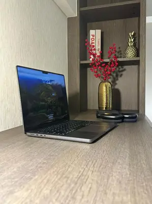 a laptop computer sitting on a table with a vase of flowers at Luxury loft with Stunning 35th Floor Views in Bangkok