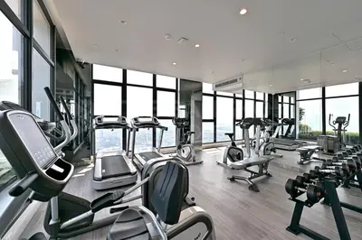 a gym with several treadmills and elliptical machines at Luxury loft with Stunning 35th Floor Views in Bangkok