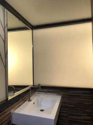a bathroom with a white sink and two mirrors at Rod Fai Fah Apartment in Bangkok