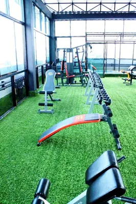 a gym with a bunch of exercise equipment on the grass at Rod Fai Fah Apartment in Bangkok