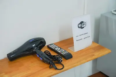 a black phone and a remote control on a shelf at GO INN Bangkok Rama3 โกอินน์ พระราม3 in Bangkok