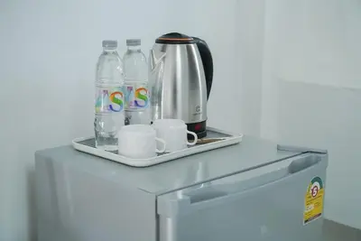a coffee pot and water bottles on top of a refrigerator at GO INN Bangkok Rama3 โกอินน์ พระราม3 in Bangkok