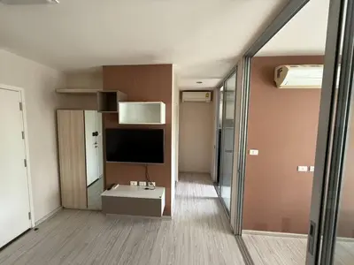 a living room with a television and a room with at Aspire Rattanatibet 2 at MRT Purple Line in Nonthaburi
