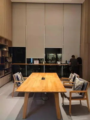 a wooden table in an office with two chairs at Aspire Rattanatibet 2 at MRT Purple Line in Nonthaburi