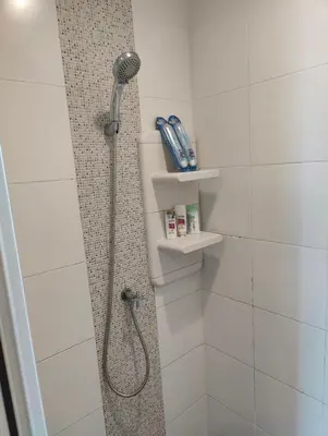 a shower with a shower head in a bathroom at Aspire Rattanatibet 2 at MRT Purple Line in Nonthaburi