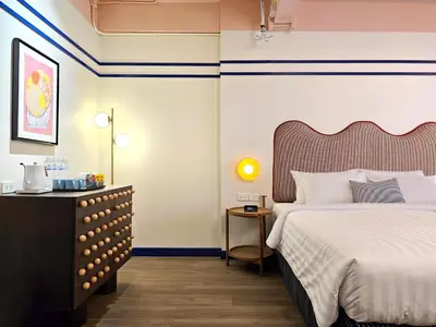a hotel room with a bed and a dresser at Blu Dock Restel Bangkok in Bangkok