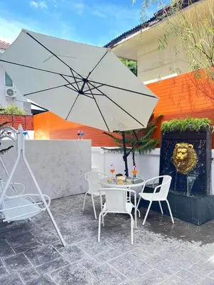 a table and chairs with an umbrella on a patio at Psalms 23 Residence in Bangkok
