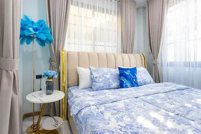 a bedroom with a bed with blue sheets and a window at Psalms 23 Residence in Bangkok