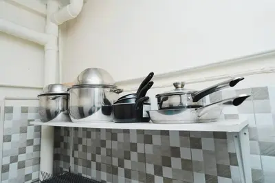 a shelf with pots and pans on it in a kitchen at 3BR Entire Home - Close to Train, Boat, IconSiam, Asiatique in Bangkok