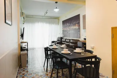 a dining room table and chairs in a living room at 3BR Entire Home - Close to Train, Boat, IconSiam, Asiatique in Bangkok