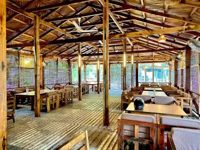 a dining room with wooden tables and chairs at Bruce House in Nonthaburi